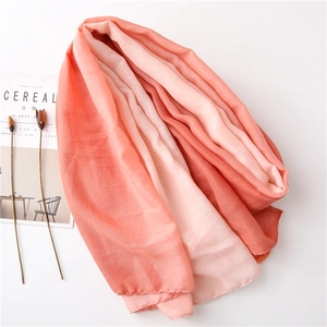 Detail of soft cotton scarf with coral gradient and delicate tassel edges