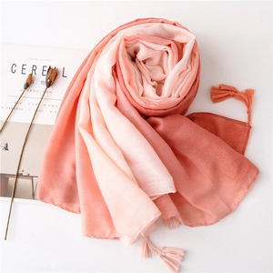 Detail of pink and brick red gradient cotton scarf with fringe on white background