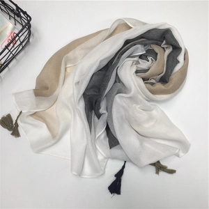 Detail of color-block cotton scarf with decorative tassels and soft geometric pattern