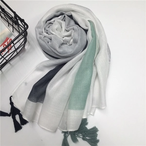 Detail of color-block cotton scarf with tassel fringe and elegant geometric pattern