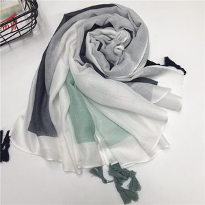 Detail view of cotton tassel scarf with grey, mint green and white geometric color blocks
