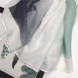 Detail shot of the cotton linen gradient scarf featuring mint green hues and tassel fringe