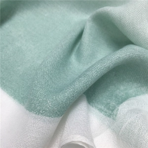 Macro shot of mint green and white cotton scarf showing fine woven texture and soft drape