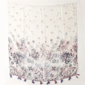 Détail d'une écharpe en coton-lin blanc avec imprimé paisley et bords à glands colorés