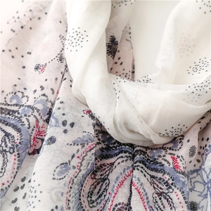 Gros plan d'une écharpe légère à imprimé paisley et élégants motifs de pois noirs