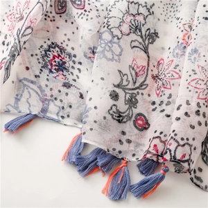 Détail d'une écharpe légère en coton avec imprimé ethnique et détails de franges colorées