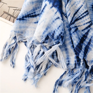Κοντινό πλάνο από λινό κασκόλ tie-dye σε μπλε και λευκό με λεπτομέρειες από υφαντά κρόσσια