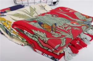 Detail of floral and butterfly print cotton scarf with decorative handmade tassels
