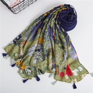 Detail of floral printed scarf featuring navy blue fabric with yellow flowers and fringe