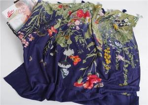 Close-up of dark blue floral cotton scarf with bird prints and stylish tassels details