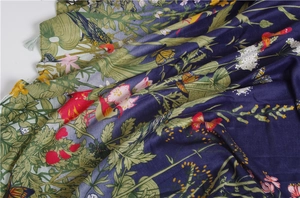 Detail of floral and bird print on navy twill scarf with fine grey tassels