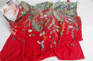 Detail of red floral scarf featuring realistic butterfly prints and gray fringed tassels