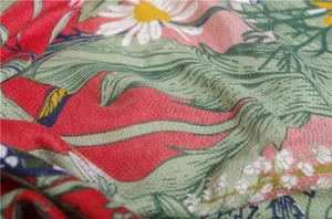 Detailed close-up of floral twill cotton scarf showing red fabric with daisy prints