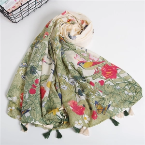 Detail of floral and bird print scarf featuring bohemian tassels on high-quality cotton fabric