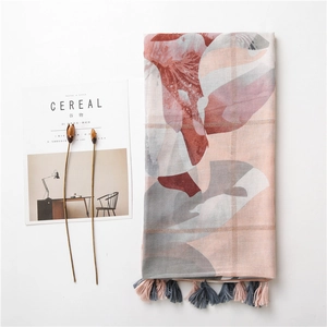Écharpe élégante en coton et lin avec imprimé floral et franges sur fond blanc épuré