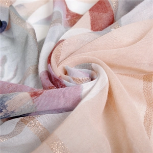 Détail d'écharpe en coton et lin rose avec imprimé camélia doré et texture de tissu doux