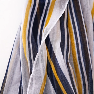 Close-up of thin striped cotton linen scarf showing breathable fabric texture in navy and yellow