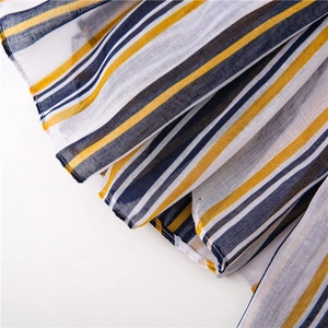 Close-up of the breathable cotton linen fabric with yellow, navy, and white stripes