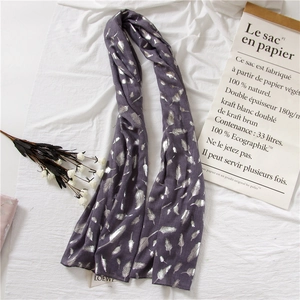 Detail of elegant silver feather print on lightweight purple cotton linen scarf fabric