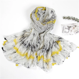 Detail of cotton linen scarf featuring black ink texture and yellow tassel accents