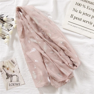 Detail of light pink linen scarf featuring metallic silver feather foil print patterns