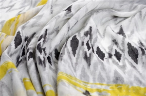 Detail of cotton linen scarf showing geometric patterns and abstract yellow brushstrokes