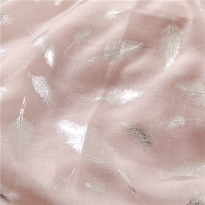 Close-up of soft pink linen scarf showing elegant silver foil feather patterns