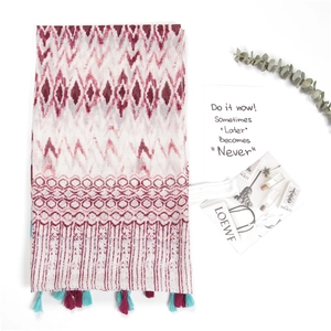 Detailed flat lay of cotton linen scarf with ikat geometric pattern and tassel fringe