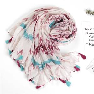 Close-up of cotton linen scarf featuring tie-dye patterns and colorful handmade tassels