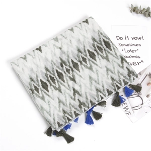 Detail of grey striped cotton linen scarf featuring blue and dark green tassel edges
