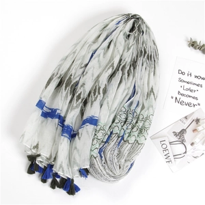 Detail of bohemian cotton linen scarf featuring colorful geometric prints and hand-tied tassels