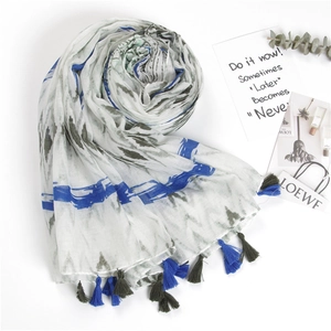 Detail of linen scarf with blue stripes, tie-dye ink patterns and two-tone tassels