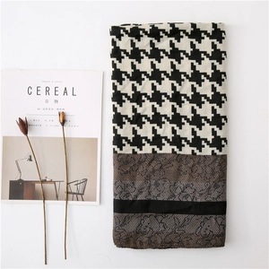 Detail of houndstooth scarf with lace splicing shown with magazine props on white background