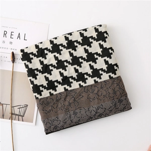Detail of houndstooth scarf with brown floral lace trim and minimalist magazine decor
