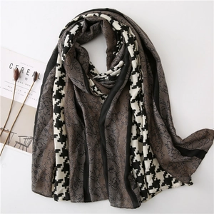 Detail of long houndstooth scarf with lace splicing and black border on white background