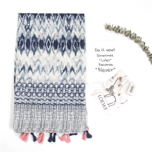 Close-up of geometric pattern scarf with colorful fringe and decorative props