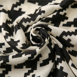 Macro detail showing woven houndstooth texture and soft drape of black white shawl