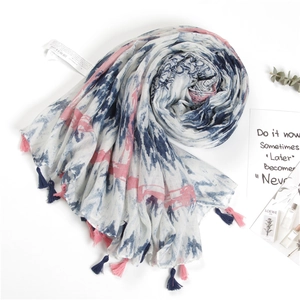 Close-up of cotton linen scarf with tie-dye patterns and handcrafted colorful tassels