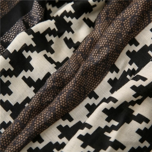 Detail of houndstooth fabric and luxury vintage monogram pattern on elegant long scarf