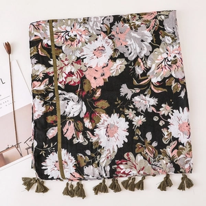 Detail of bohemian beach shawl with floral print and olive green fringe tassels