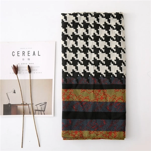 Detail of houndstooth scarf with geometric patterns and elegant lace patchwork design