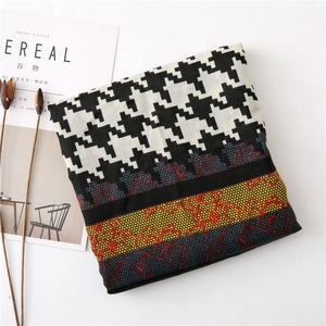Detailed shot of houndstooth scarf with colorful ethnic borders on a white background