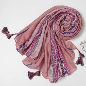 Detail of ethnic style pink shawl with geometric patterns and tassel fringe decorations