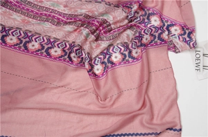 Detailed view of pink bohemian shawl featuring tassels and intricate geometric patterns