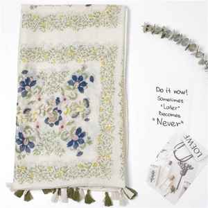 Détail de l'écharpe en coton et lin à imprimé fleuri avec des franges faites à la main