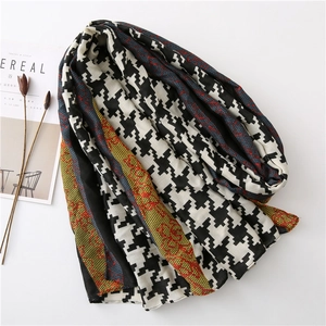 Detail of houndstooth scarf with colorful borders and soft texture on white background