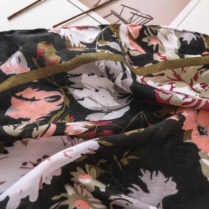 Macro view of bohemian beach scarf showing fine floral print texture and weave details