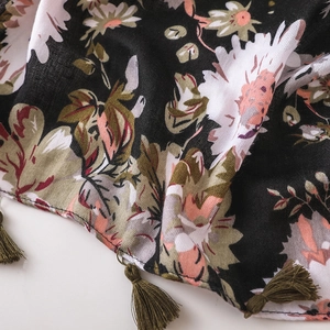Detailed macro view of bohemian black floral fabric with fringe tassel edges