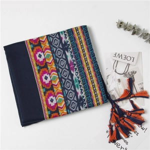 Detailed view of ethnic style dark blue shawl with vibrant geometric prints and tassels