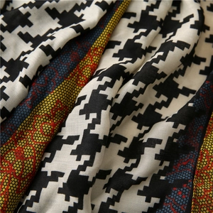 Macro detail of houndstooth scarf with colorful vintage border and woven texture